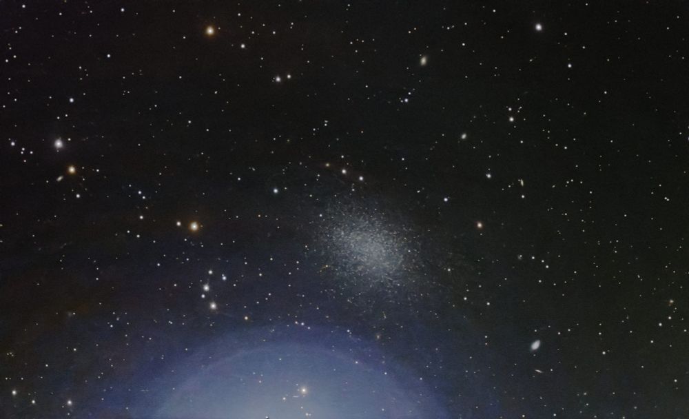 The dwarf galaxy Leo-1 just 12 arc min north of the bright star Regulus as imaged with a Celestron Origin smart telescope. 600 subs of 10s where stacked resulting in a limiting magnitude of 19mag.