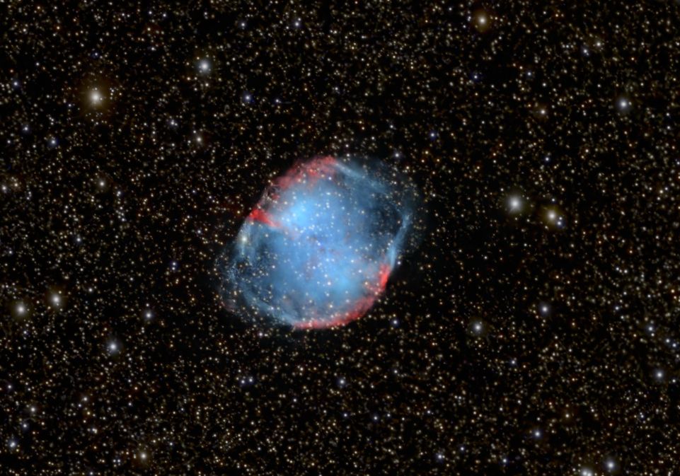 A gas nebula glowing in intensive blue and red light in front of a star-spangled milkyway.
