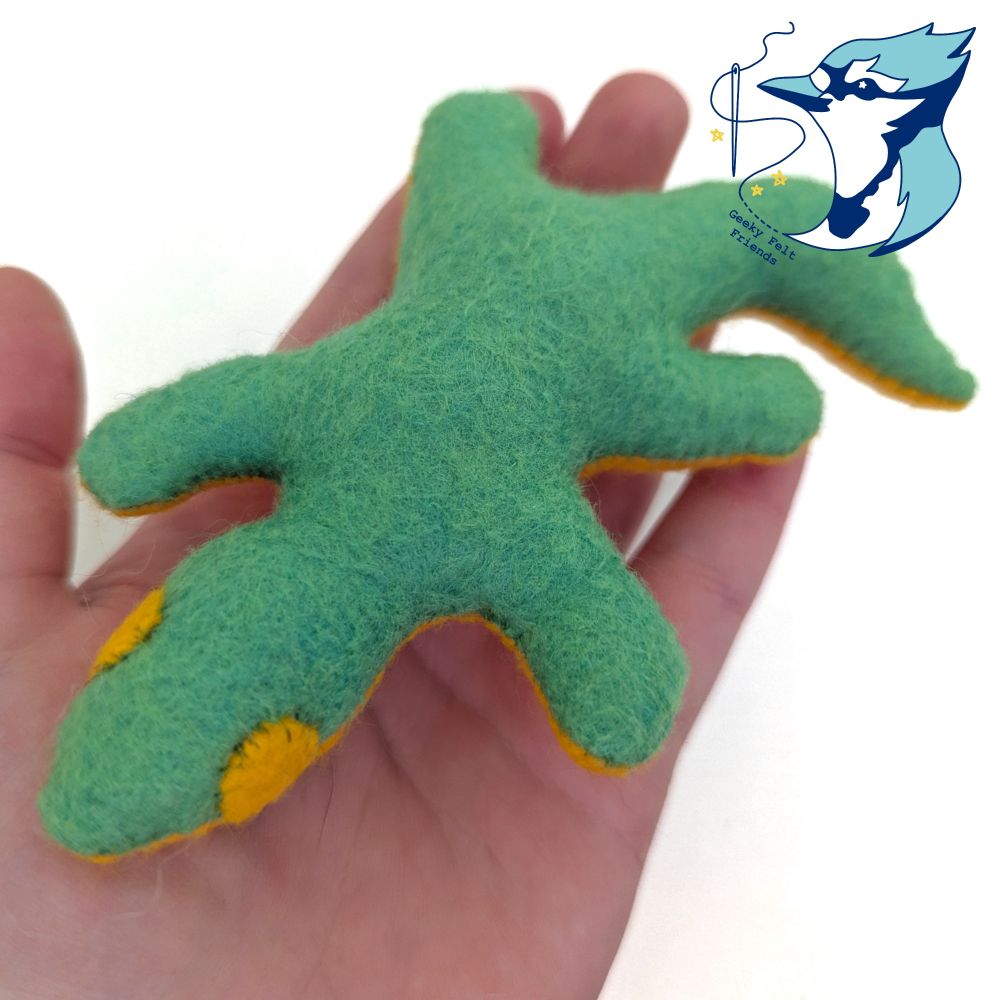 A photo of a simple plush lizard in green and gold