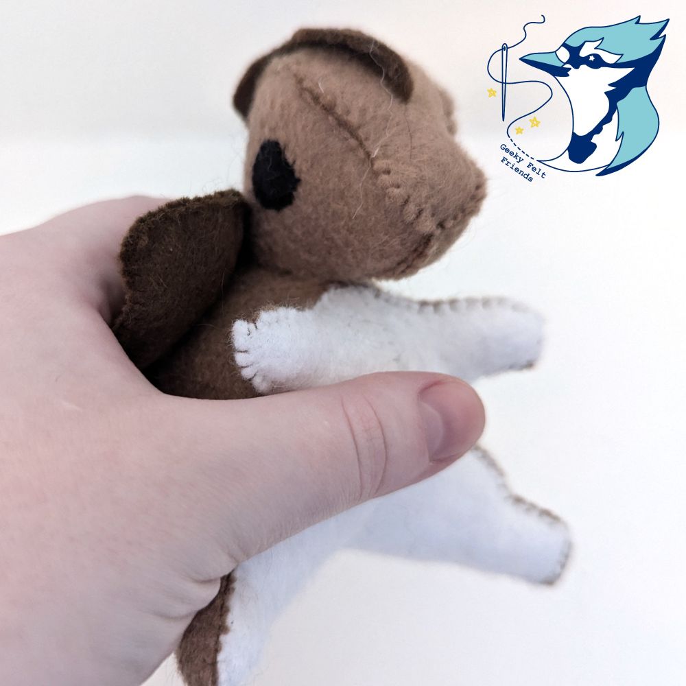 A closer photo of a brown and white baby dragon plush
