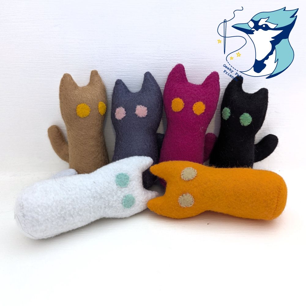 A photo of six simple plush cats in various colors
