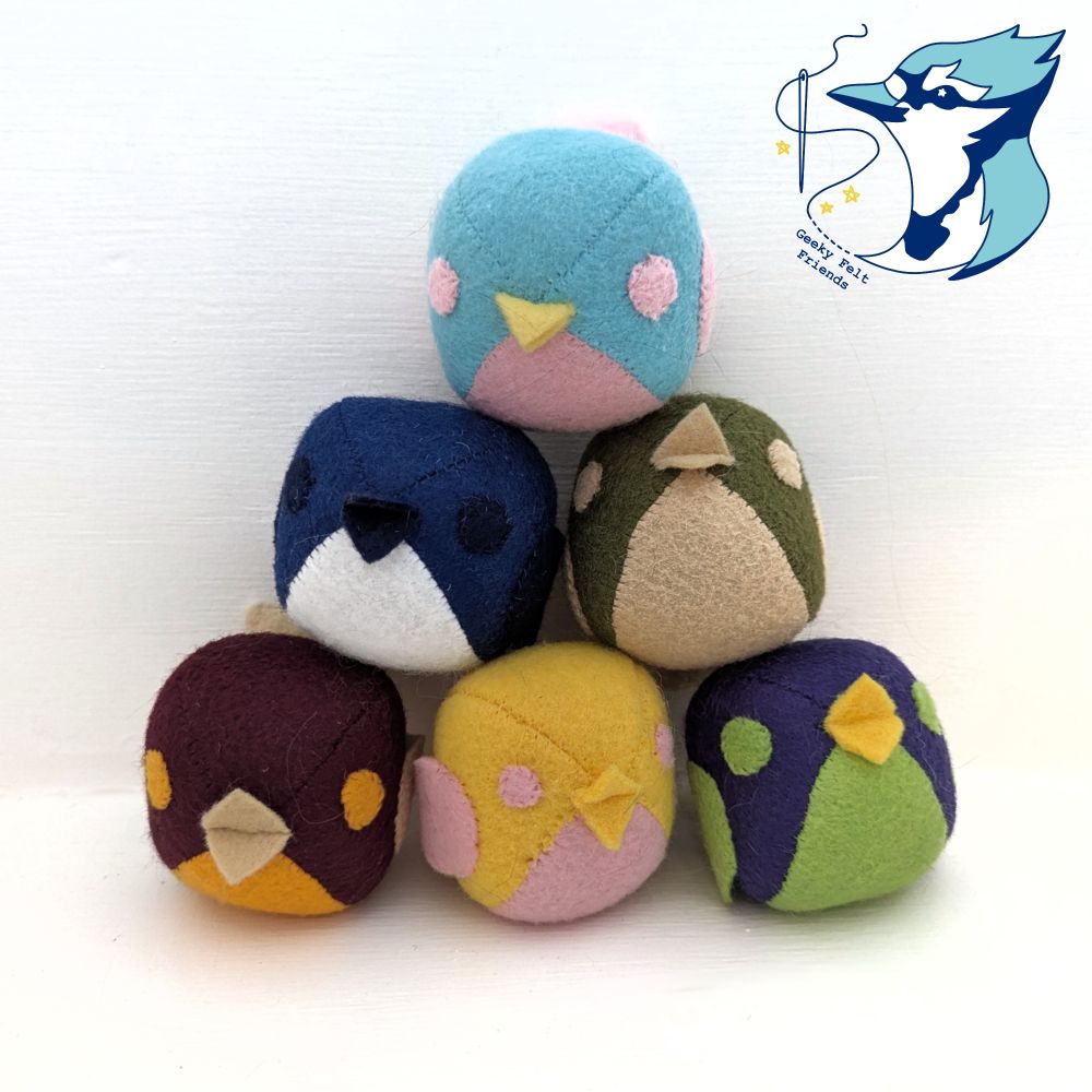 A photo of six round simple plush birds in various colors