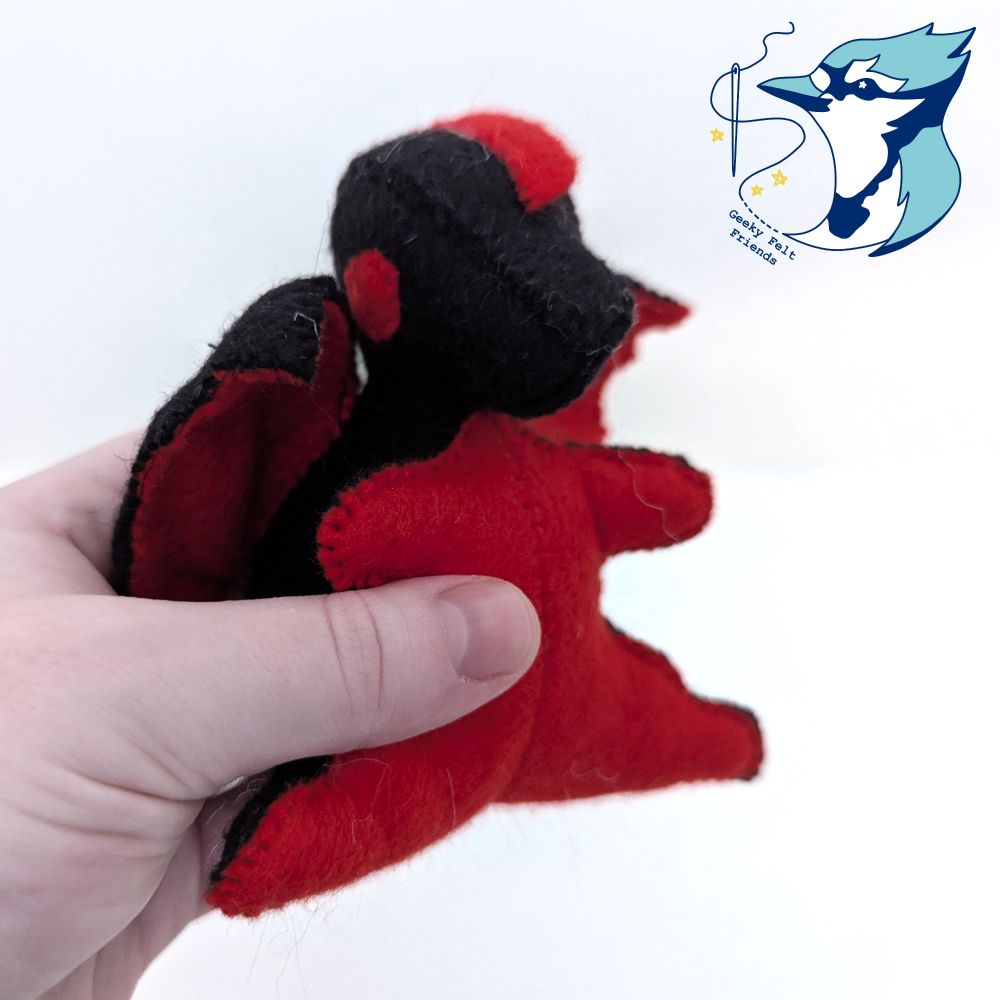 A closer photo of a black and red baby dragon