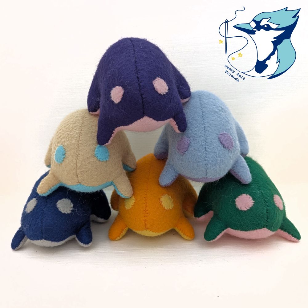 A photo of six simple shaped plush frogs in different colors