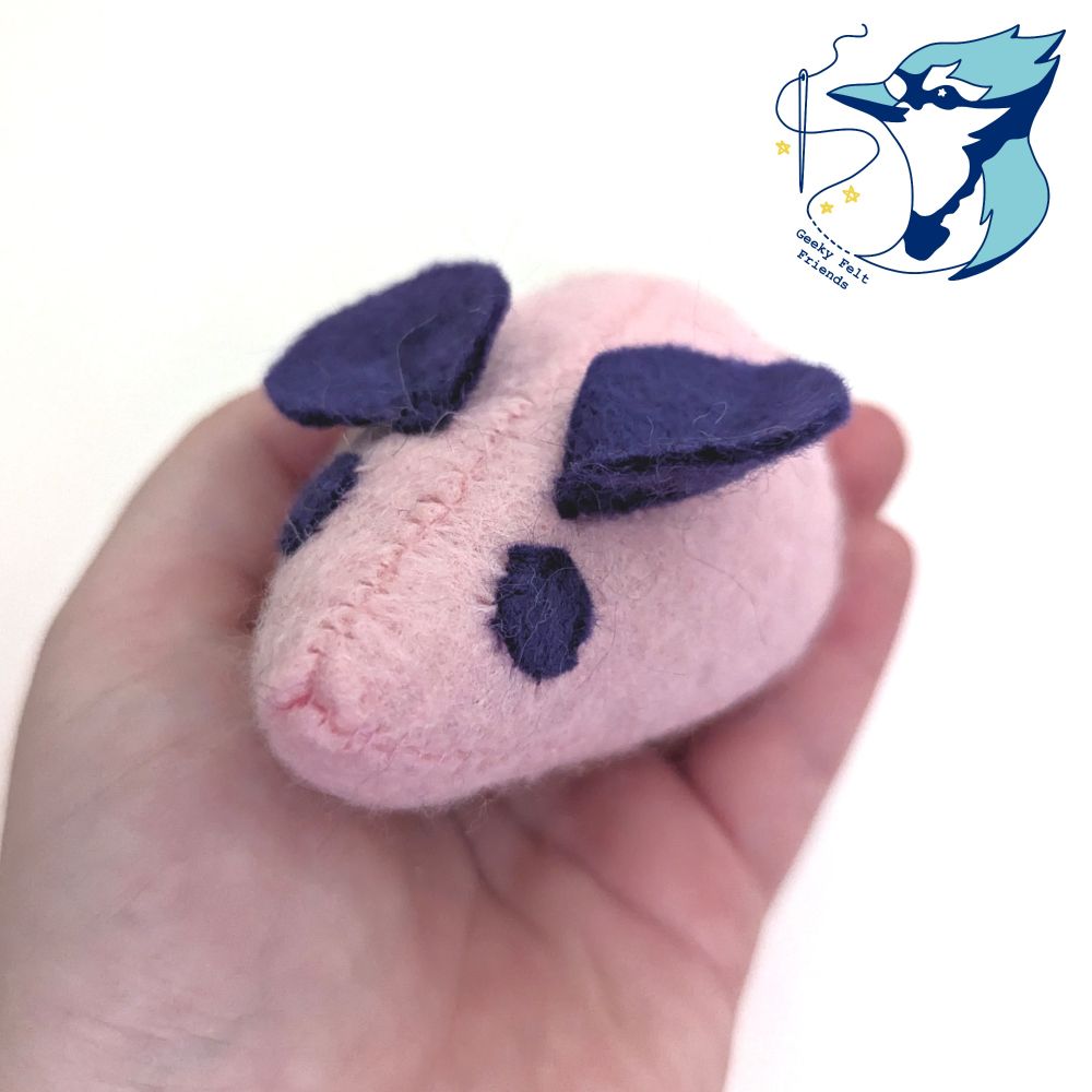 A closer photo of a simple pink and purple plush mouse