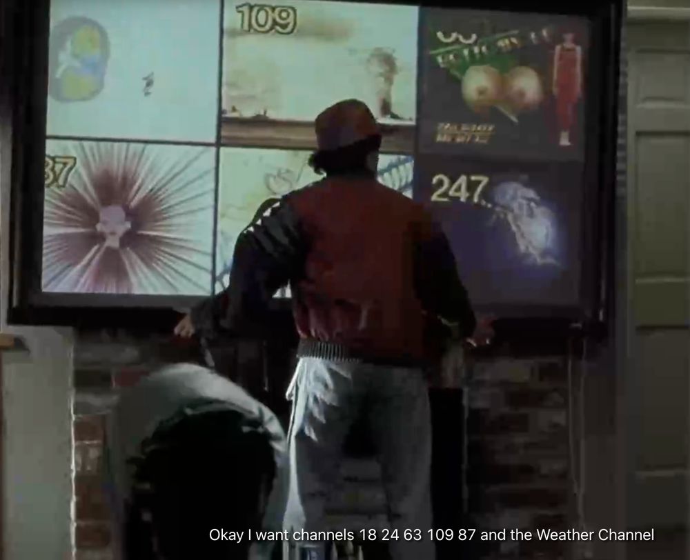 Scene from Back To The Future II. Marty McFly, dressed as a youth of the future gives oral instructions to his tv. "Ok I want channels 18 24 63 109 87 and the Weather Channel" the tv display is huge and has the six channels in 1:1 ratio segments