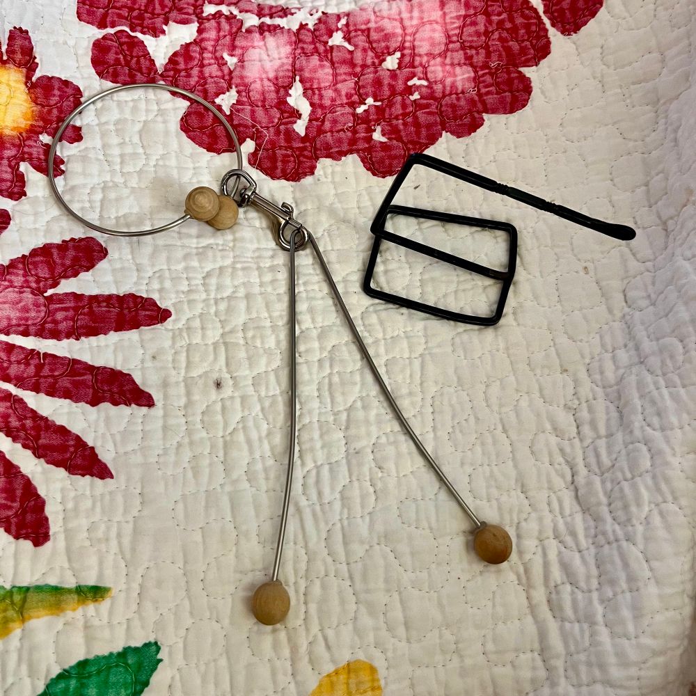 Two yarn holders I’ve had for years. So long that I can’t remember who made them.  The black one is wrought iron and fits over your belt. The silver one hangs from your wrist.