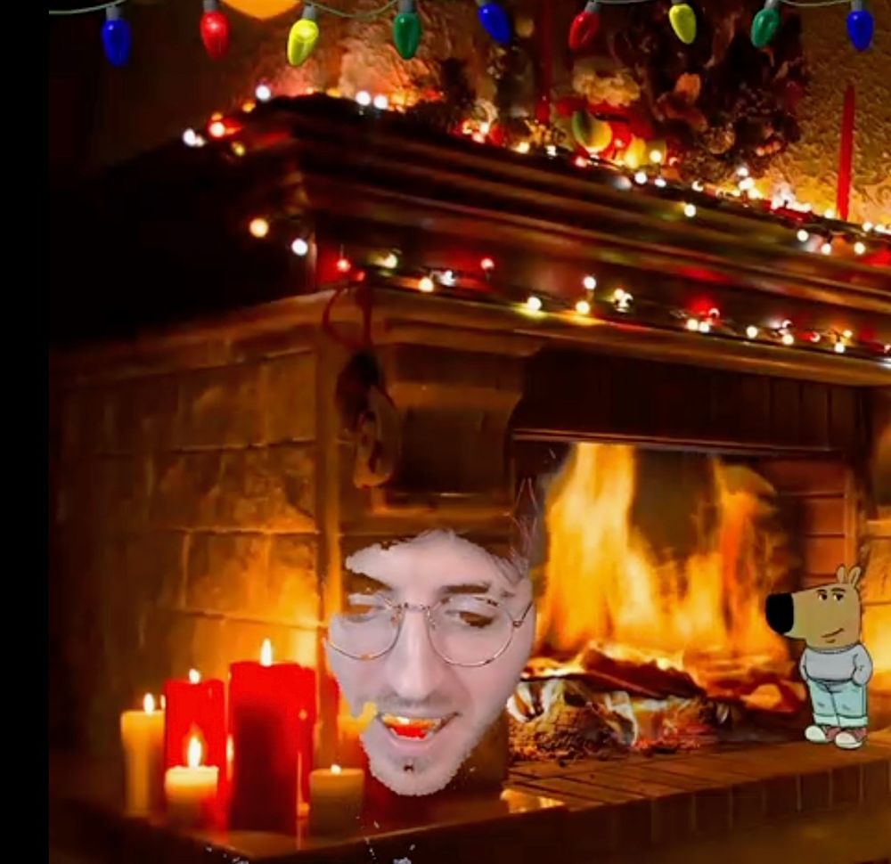 A picture of Whisqey’s head floating on a green screen, with the background being a cozy fire and the chill guy character standing off to the right. Whisqey’s hair, neck, and shirt disappeared due to the green screen, and their face had spots that blend in with the green screen.