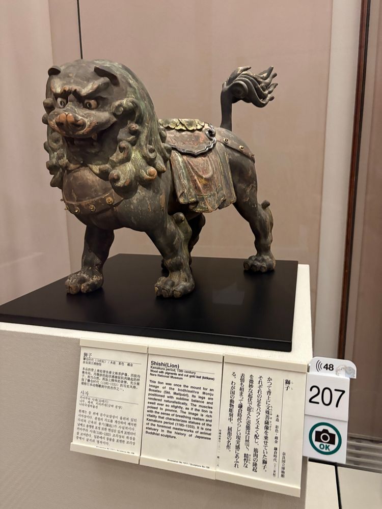 奈良国立博物館 仏像館
獅子 木造・彩色・截金 鎌倉時代(13世紀)
キャプションには「かつて背上に文殊菩薩像を乗せていた物。それぞれの足をバランスよく配し、筋肉の降起を微妙な起伏で捉えた姿勢は自然で、精悍な表情も相まって鎌倉時代らしい現実感にあふれる。わが国の動物彫刻中、尻指の名作」とある。
目が大きめでくりくりとしており、眉根を寄せているが寄り目のようになっていて、迫力もあるがなんともいえない愛嬌も感じる。