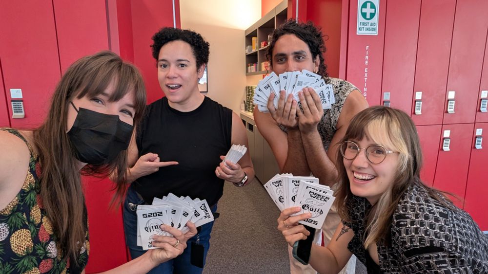 Four union members hold up zines, smiling.