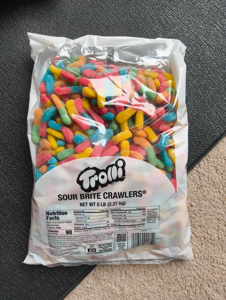 The picture displays a 5lb plastic bag full of multicolored gummy worms.