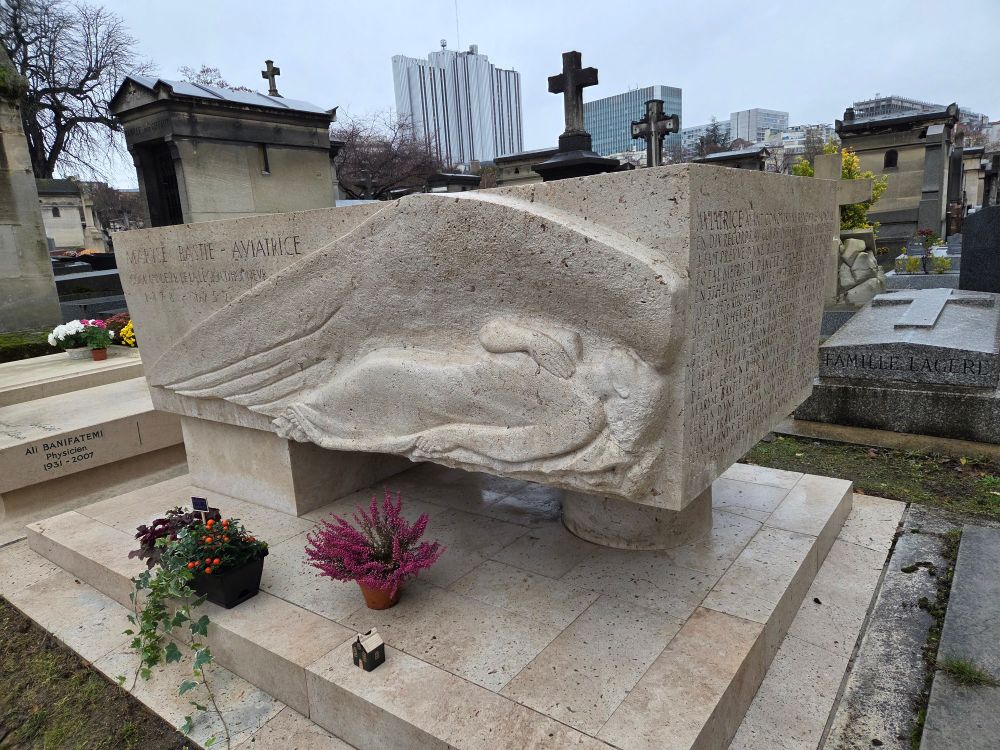 Tombe de Maryse Bastié au cimetière Montparnasse, ornée d'un monument dont cette face représente une femme allongée, sous une longue aile