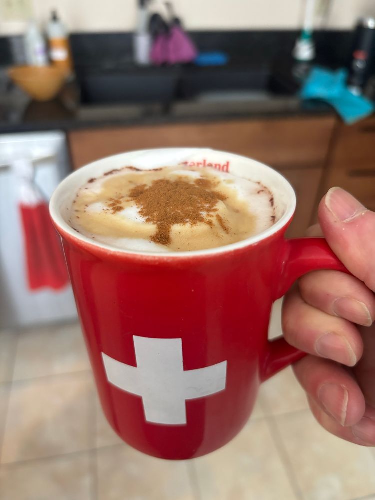 A mug with the Swiss flag filled with hot chocolate. 