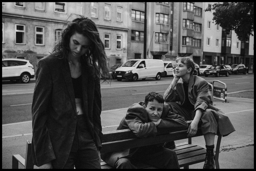 part of a photo series. durational perfomance: three bodies exploring rest as practice of resistance and togetherness.

photo: 
three young people wearing suits using a bench next to the street in unusual ways 