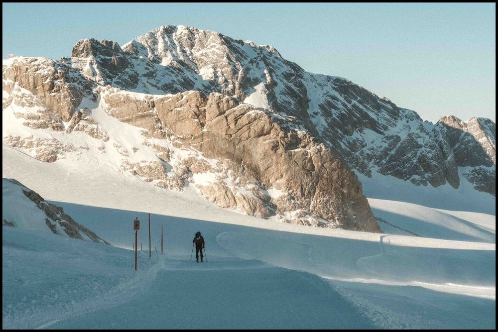 a cross-country skier on a trail towards a mountain