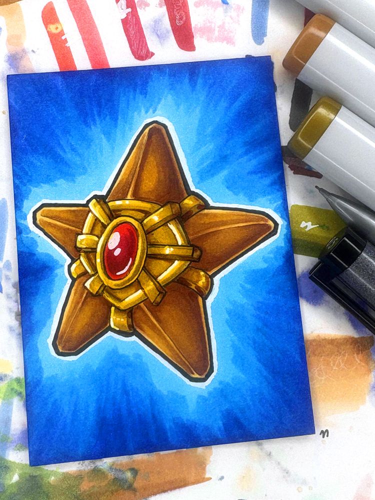 A photo of an ACEO marker drawing of Staryu at 3/4 view. The background is a blue vignette. The photo is taken on top of a sheet of paper with many marker streaks, with a few markers visible at the side of the photo. Drawn for Pokécember day 3 “Water”.

Art by Megzie Sass-Council #ArtByMegzie #pokecember #pokécember  #pokecember2025 #pokécember2025 #staryu