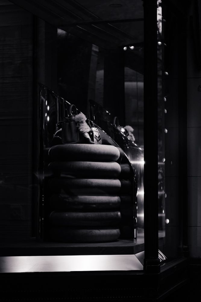 A shop display window with a velvet textured ring cushion in high contrast lighting 
