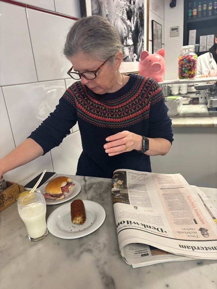 In Eetsalon Van Dobben, Jane is reading Het Parool, eating a croket and a beef broodje, and drinking karnemelk / buttermilk. 
