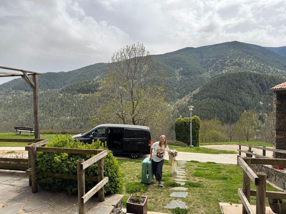 A picture of me carrying stuff out of a van. Mountains in the background.