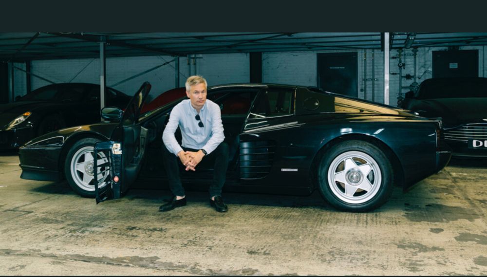 Das Foto zeigt Poschardt in der offenen Tür seines Ferrari sitzend, mit der Sonnenbrille lässig im Halsausschnitt eingehängt.