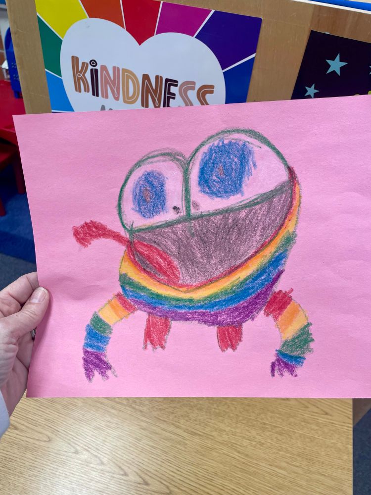 A child’s drawing of a rainbow colored frog. 