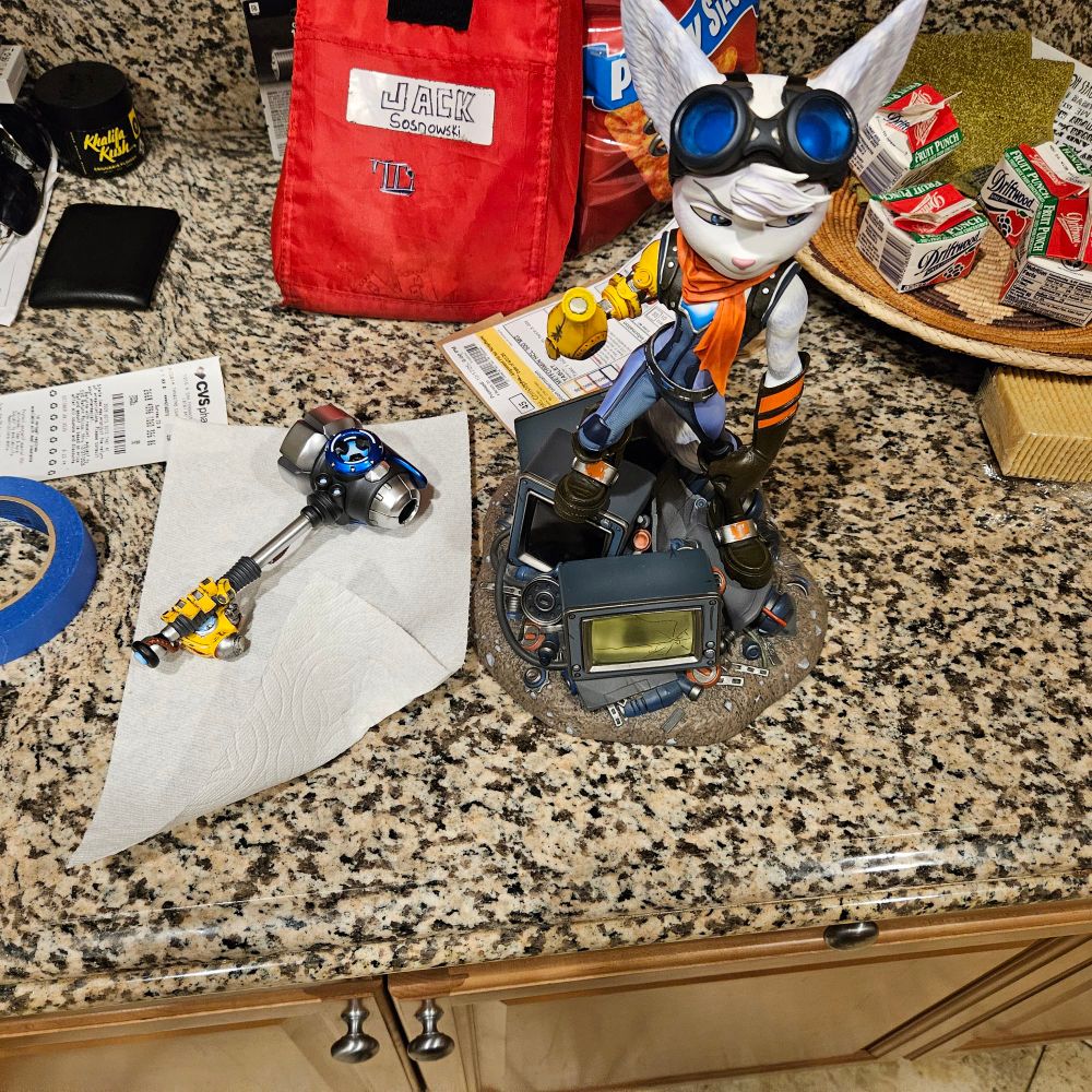 Statue of Rivet from Ratchet and Clank: Rift Apart.
The robotic hand gripping her hammer is broken off and lying on the counter next to the rest of the statue.