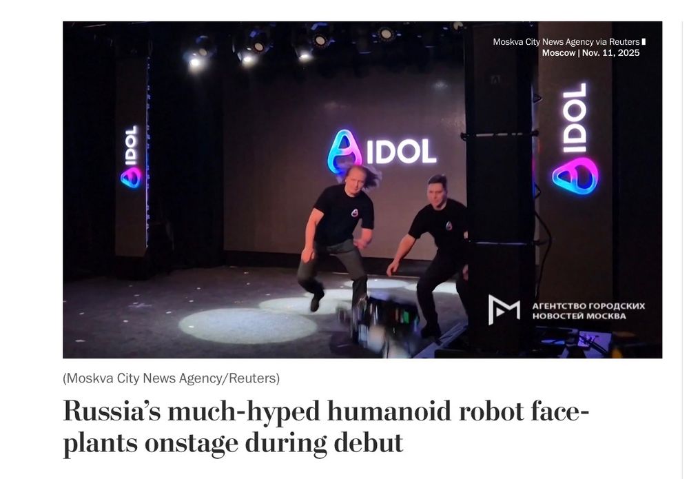 Screenshot of a news article, with the headline “Russia’s much-hyped humanoid robot face-plants onstage during debut”. Above it is a frozen still of a video of a stage, with two men frantically leaping toward a blurry mass crashing into the floor.