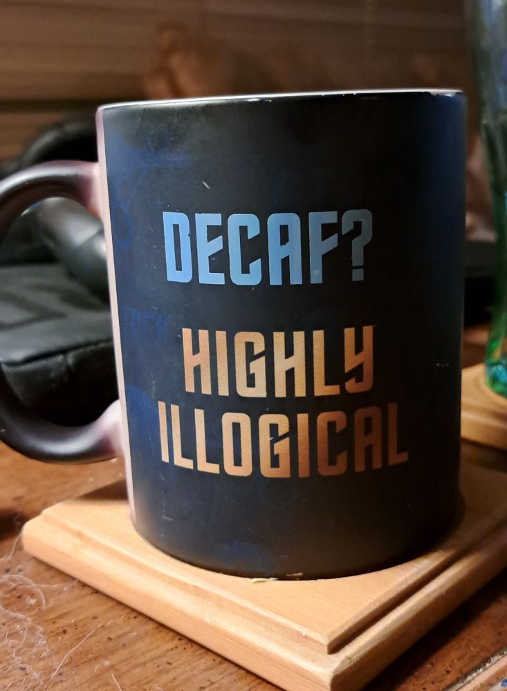 A black coffee mug with the words 