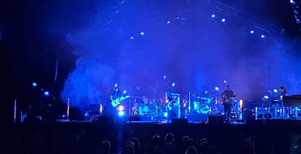 Jason Isbell performing on stage with blue lights in Kelowna.