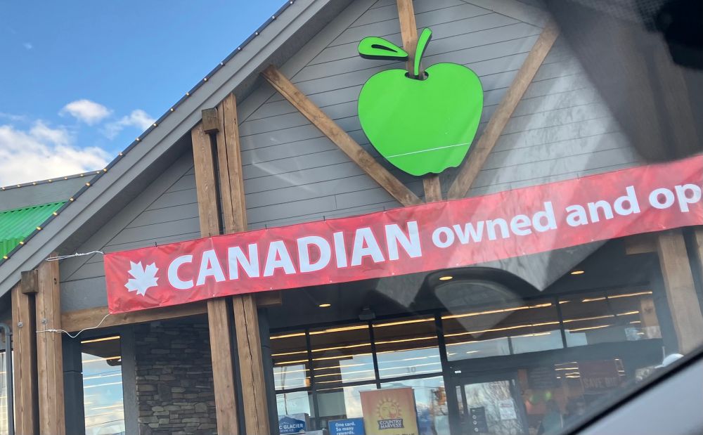 Super market in Canada with banner reading “Canadian owned and operated” out front.