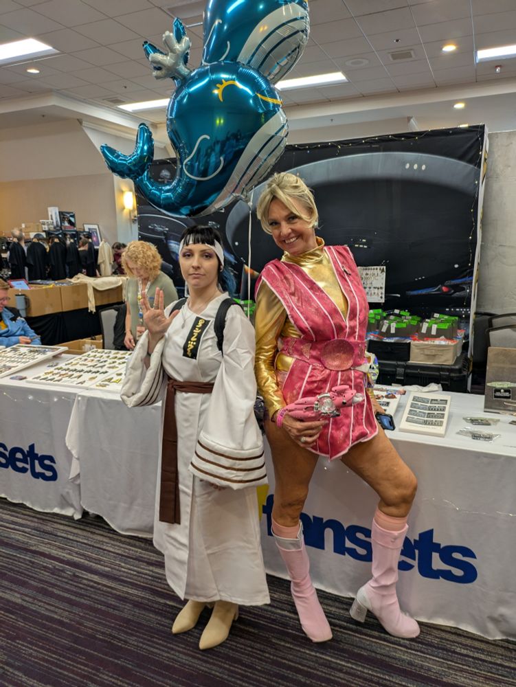 Star trek cosplayers, to the right Spock from the voyage home with two whale balloons above, to the left a SNW cosplayer