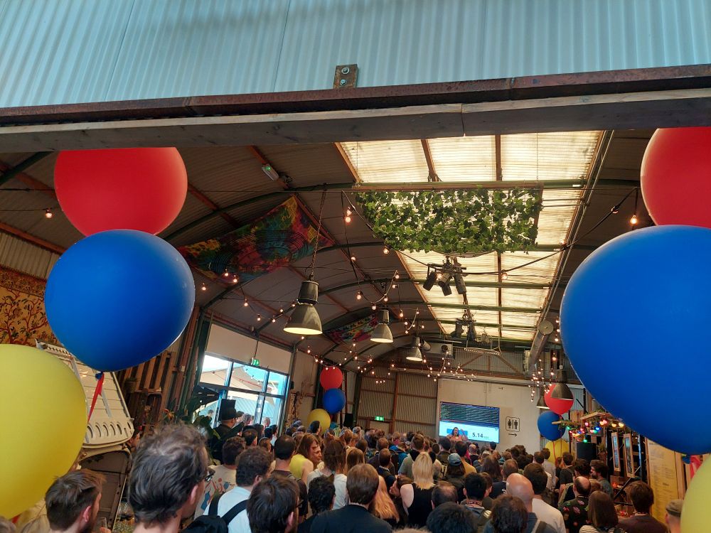 A large room with balloons and a crowd of people