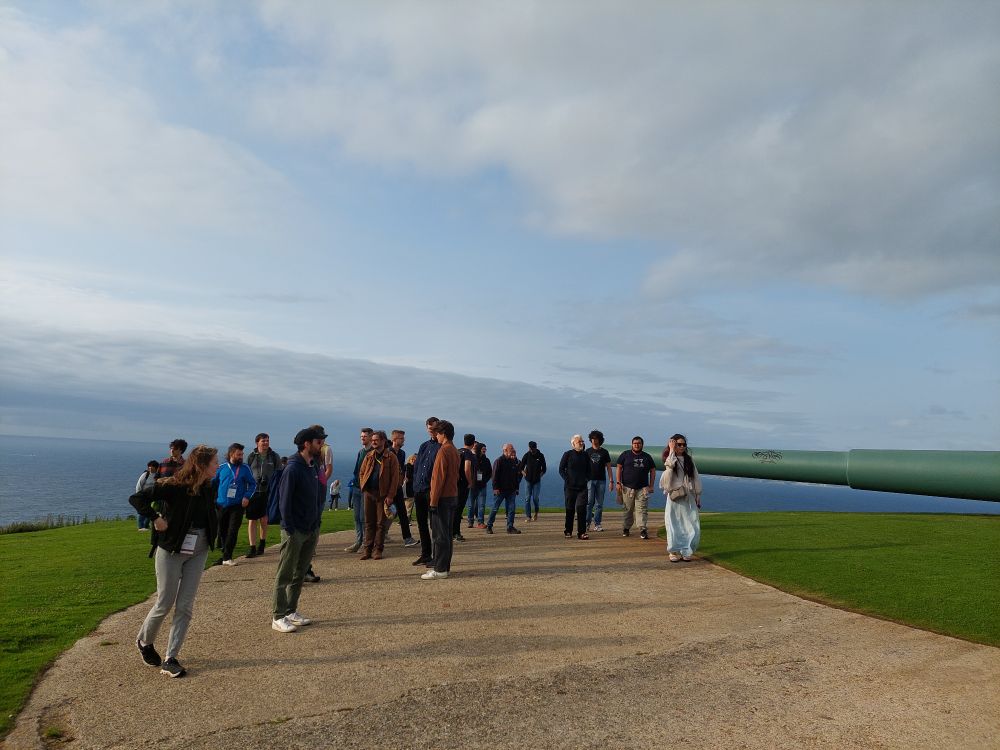 People standing on well manicured green space with views behind