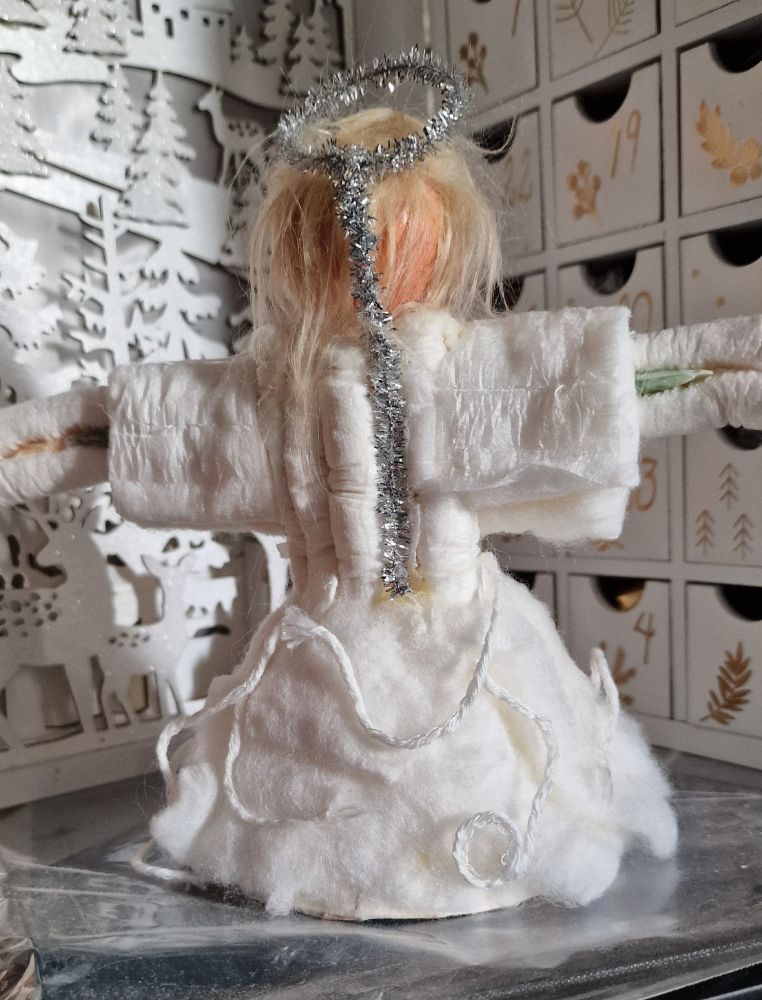 Photo' of the rear of a home made model of a menstruangel Christmas tree ornament, as seen on the TV show, Wynonna Earp. The photo' shows the rear of the model, featuring the wings and halo made of tinsel. 