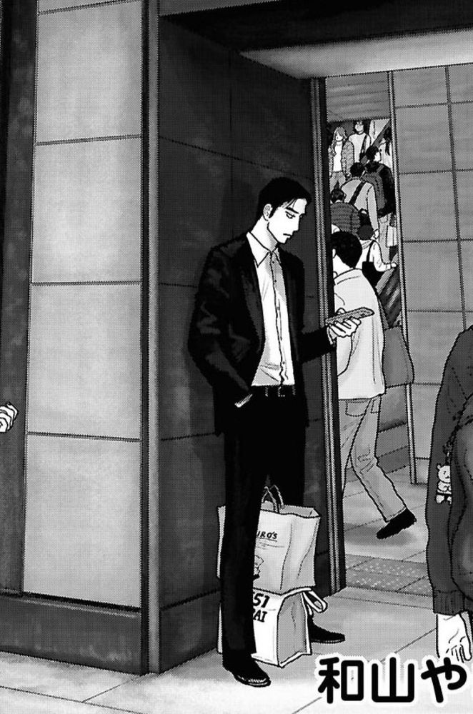 manga screenshot of narita kyouji looking down at his phone, hand in pocket, with a bag of uncle rikuro’s stacked on top of another bag from 551 