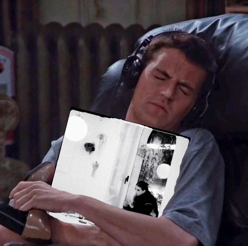 A white man (Matthew Perry from Friends) sitting with headphones) hugging a vinyl and holding a shoe. Young Miko’s Do Not Disturb latest album cover has been photo shopped on the vinyl cover. 