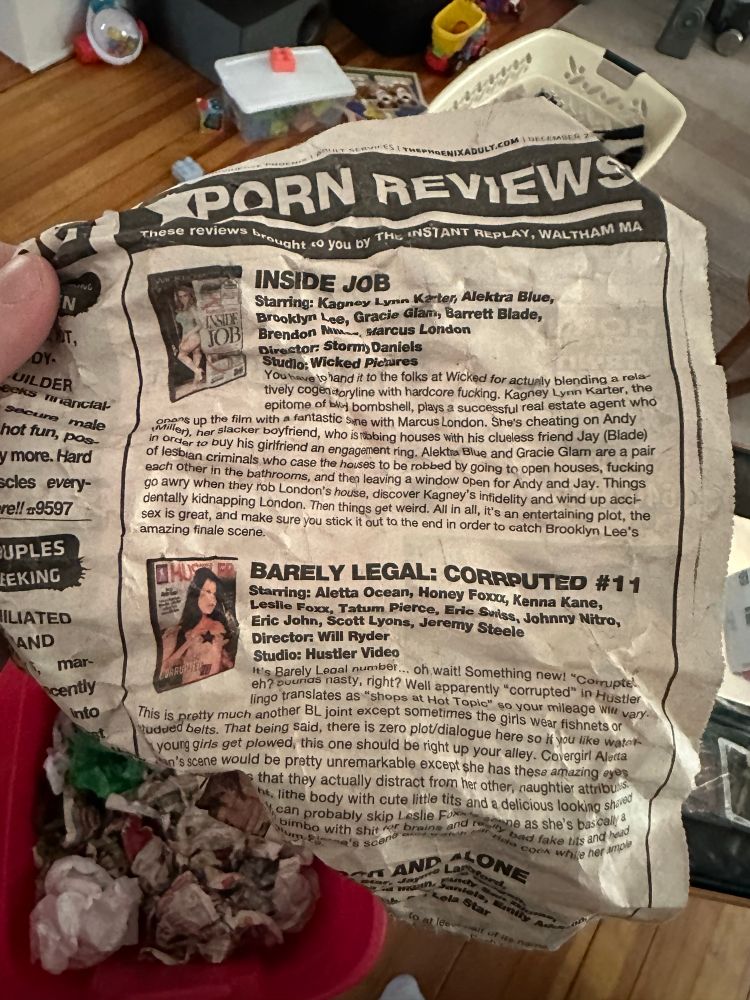 Close up of one of those crumpled newspapers showing the headline that reads, “PORN REVIEWS”