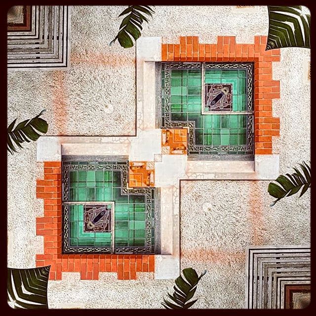 Mirrored view of tiles, stucco and palm leaves at a convent