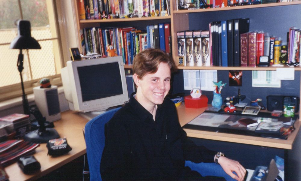 Me aged 15 sitting at my desk in my bedroom, 2002. A large CRT monitor and various early 2000s artefacts litter the period computer desk