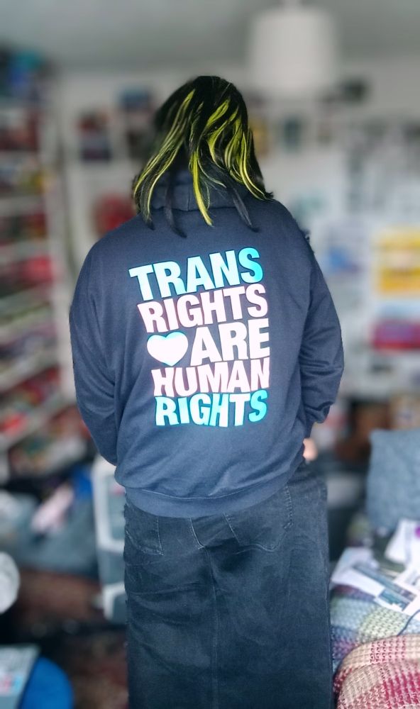 Blue hoodie worn by pretty trans woman. Message reads. 

"Trans rights are human rights"