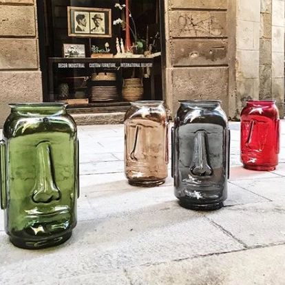 A tastefully arranged collection of glass vases shaped like Easter Island heads, sourced from the original manufacturer in Barcelona, Spain