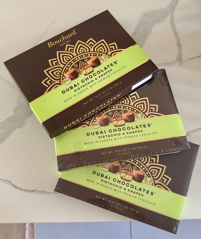 A picture of 3 boxes of Bouchard Dubai chocolates with pistachio and knafeh fanned out. 