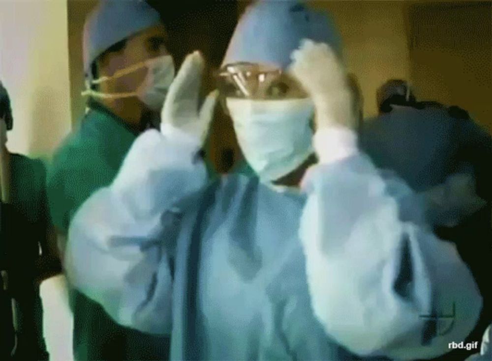 a gif of a surgeon putting on his gown and gloves