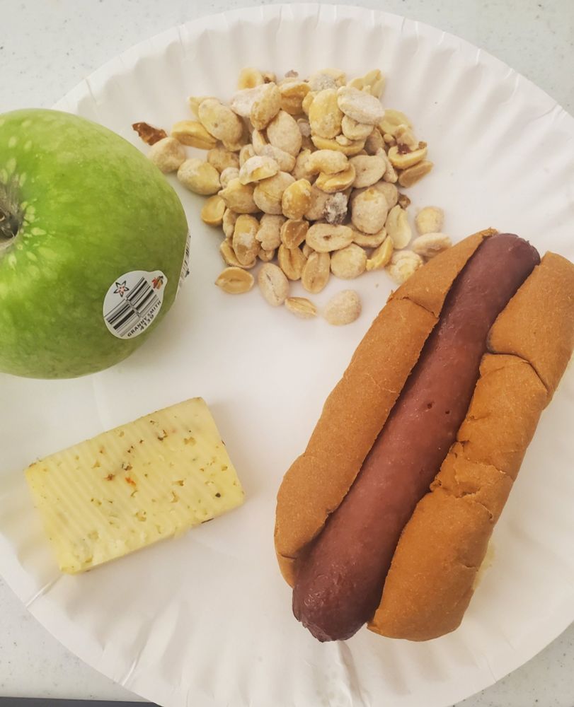 a beef hot dog, a slice of jalapeño harvarti cheese, a granny smith apple and a handful of dry roasted peanuts