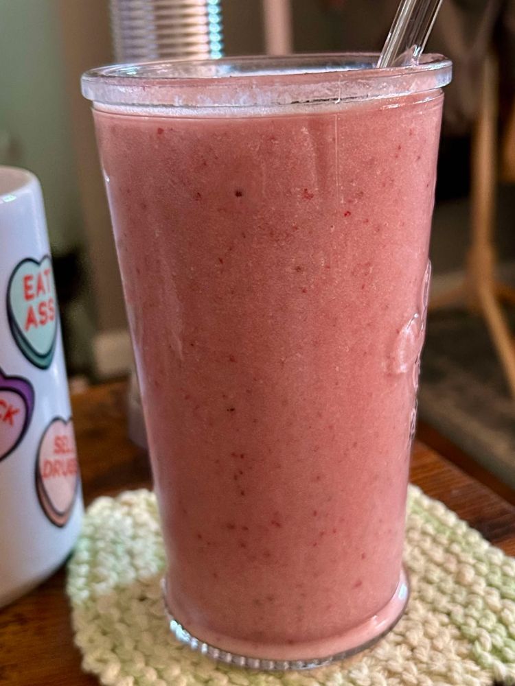 A protein smoothie with Ryze Jet Puffed Protein Powder, frozen strawberries, collagen powder, vitamin d & k + psillyum husk. 

Next to a coffee mug based on an old John Mulaney bit. It has conversation hearts that say "Eat Ass", "Suck Dick" and "Sell Drugs"