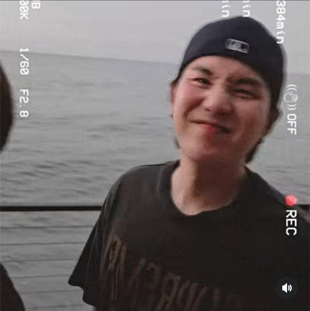 YOOOOOONGIEHHH! SUGA OF BTS LOOKING ADORABLE IN A BLACK GRAPHIC TEE AND BACKWARDS BASEBALL CAP SCRUNCHING HIS LIL NOSEY ON THE PATIO OF A CALIFORNIA RESTAURANT OVERLOOKING THE WATER. FROM A VIDEO POSTED TO IG STORIES BY J-HOPE OF BTS