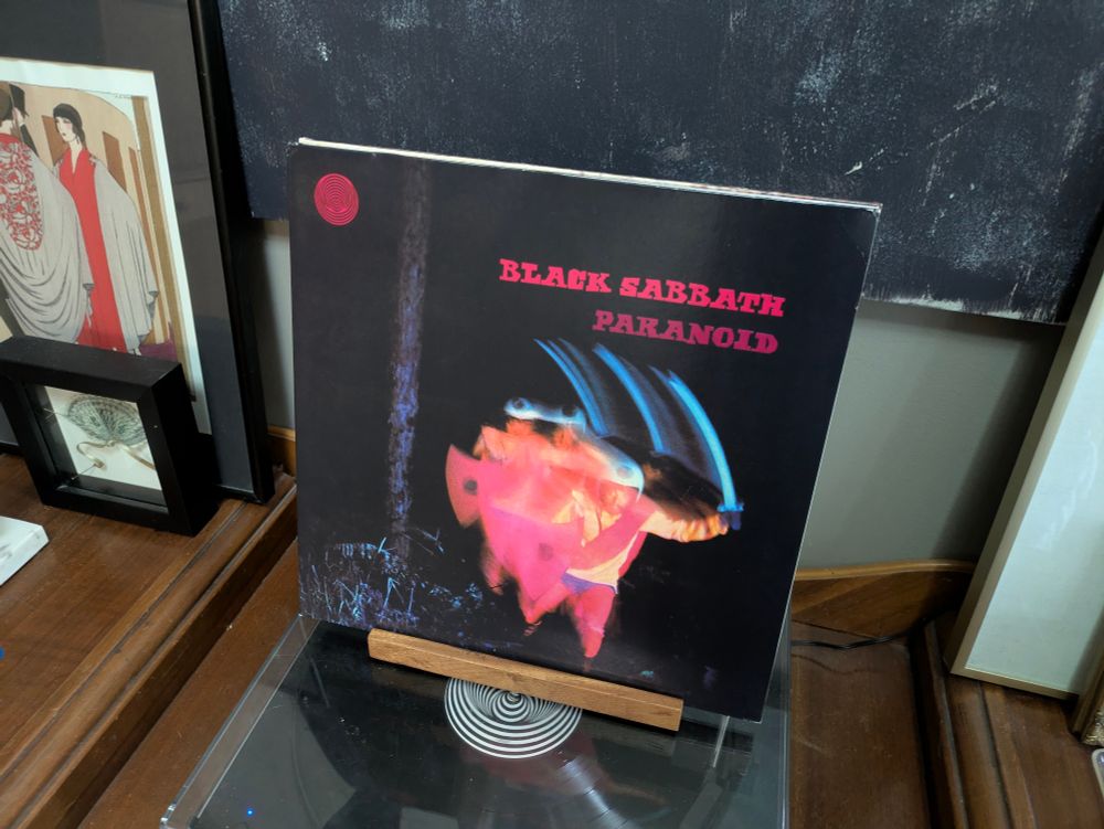 The record cover for Black Sabbath's album, Paranoid, featuring a psychedelic, multi-exposure photo of a swordsman in pink and blue hues.