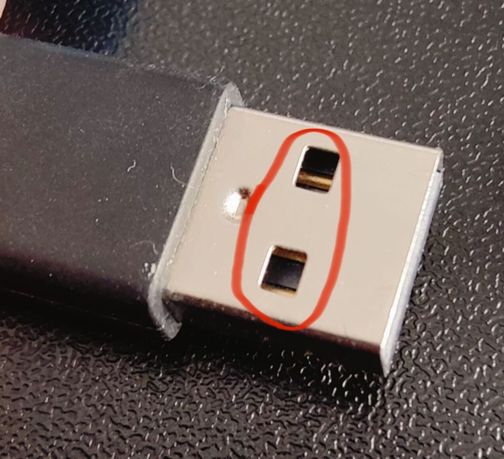 USB-Stecker in Nahaufnahme mit roter Markierung um die offenen Vierecke im Metallteil.