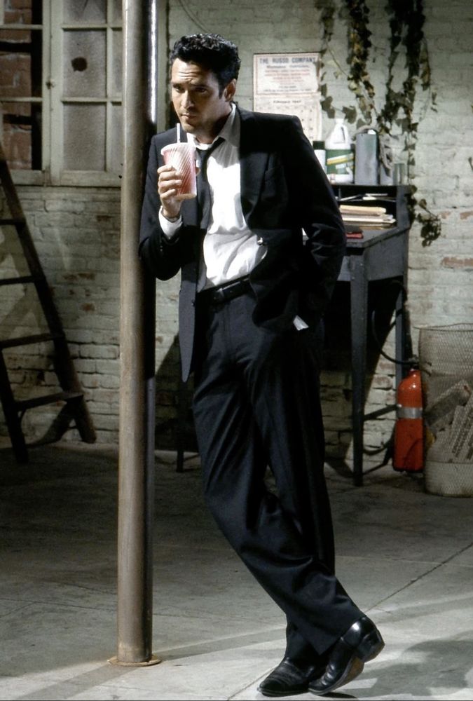 Michael Madsen as Vincent Vega’s brother Vic aka Mr. Blonde in Reservoir Dogs (1992), casually sipping a soda while leaning against a support beam and looking so, so cool