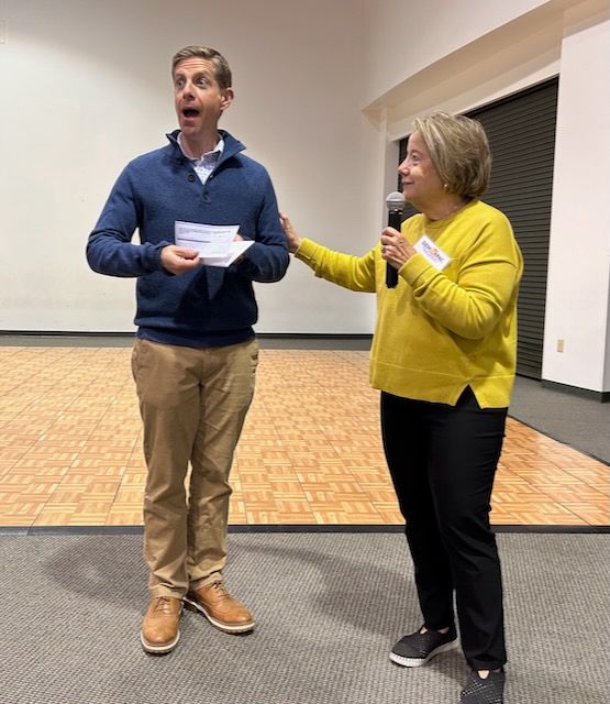 Rep. Mike Levin reacts with surprise as he's handed a donation check on behalf of DemOC PAC members (Democrats of Orange County Political Action Committee). 